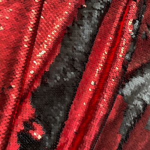 Puede incluir: Tela de lentejuelas roja y negra con un acabado brillante e iridiscente. La tela está hecha de pequeñas escamas superpuestas que crean un efecto texturizado y escamoso.
