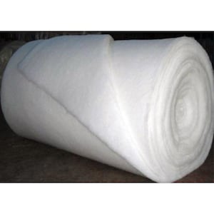 May include: A large roll of white batting material. The material is tightly rolled and appears soft and fluffy. The edges of the roll are visible, showing the layers of the material. The background is dark.