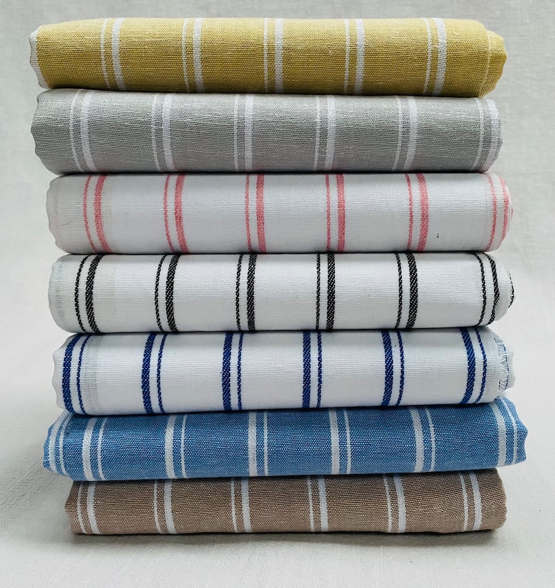 May include: A stack of eight striped fabric swatches in various colors, including beige, gray, white, pink, black, blue, and brown.