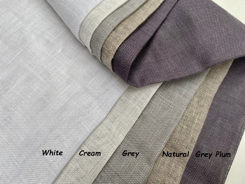 May include: Close-up of six fabric swatches in various shades of gray, including white, cream, gray, natural, gray, and plum. The swatches are arranged in a fan shape, with the white swatch at the top and the plum swatch at the bottom.