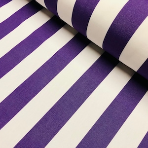 May include: Close-up of a fabric roll featuring bold, diagonal stripes. Alternating bands of white and deep purple create a striking pattern. The fabric's texture is visible, suggesting a durable material suitable for various projects.