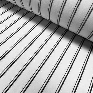 May include: White fabric with thin black stripes. The fabric is folded in half, showing the stripes running diagonally.