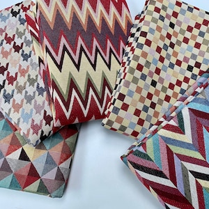 Puede incluir: Cinco muestras de tela con diferentes patrones geométricos. Las muestras son en tonos de rojo, azul, verde, amarillo y negro.