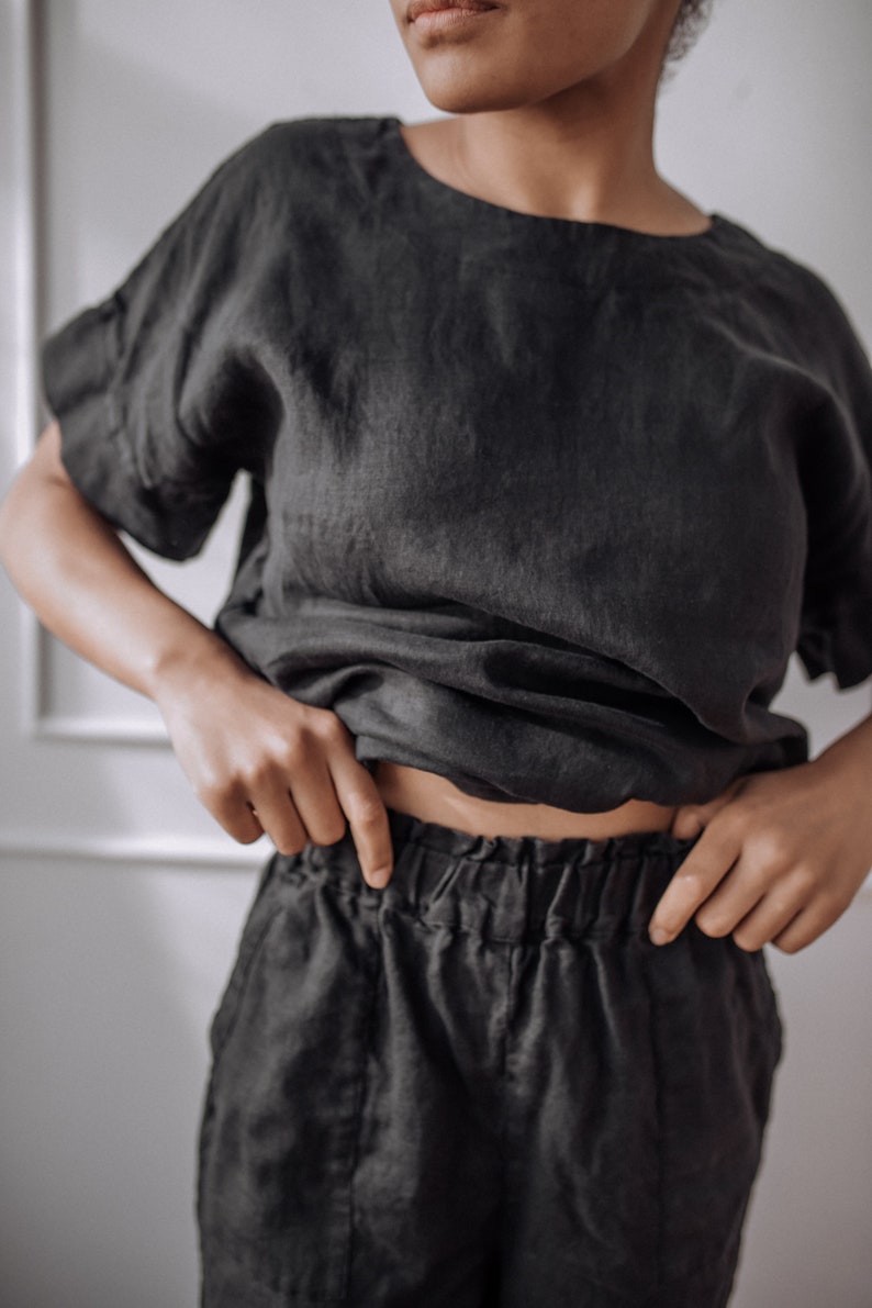 Peut inclure: Un haut en lin noir &agrave; la coupe ample et aux manches courtes, associ&eacute; &agrave; un pantalon en lin noir avec une taille &eacute;lastique.