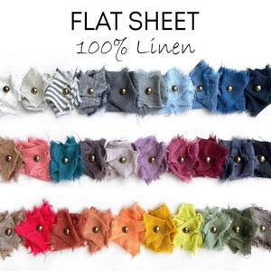 May include: A color swatch set for a flat sheet made of 100% linen, featuring three rows of frayed fabric samples in various colors, each secured with a small brass-toned metal stud. The text FLAT SHEET 100% Linen is printed at the top.
