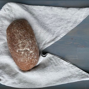 Peut inclure: Un pain brun foncé sur un tissu en lin gris clair.