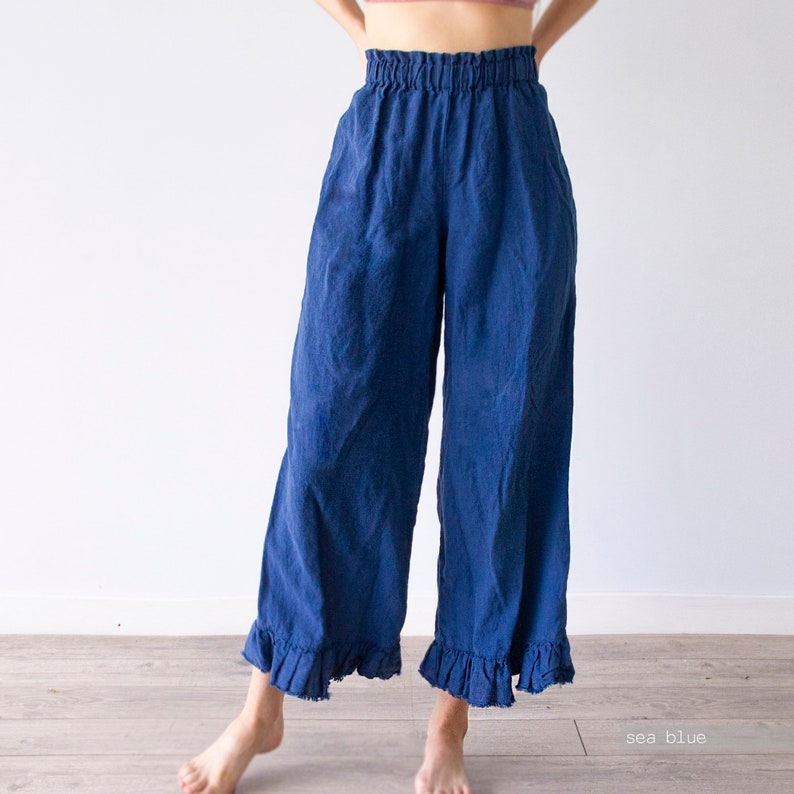 May include: Sea blue wide-leg linen pants with a ruffled hem. The pants have an elastic waistband and a relaxed fit.