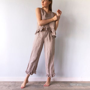 May include: A linen pants and top set in a light brown color. The top has a ruffled hem and the pants have a ruffled hem at the bottom. The pants have an elastic waistband. #flaxgray