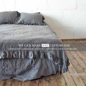 Puede incluir: Una falda de cama de lino gris antracita con un borde con volantes. El texto "WE CAN MAKE ANY CUSTOM SIZE (ORDER THE CLOSEST SIZE AND PUT A NOTE WITH YOUR CUSTOM SIZE)" está impreso en la falda de cama.