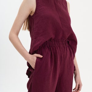 May include: A burgundy linen tank top and matching wide-leg pants. The top has a scoop neck and the pants have an elastic waistband.