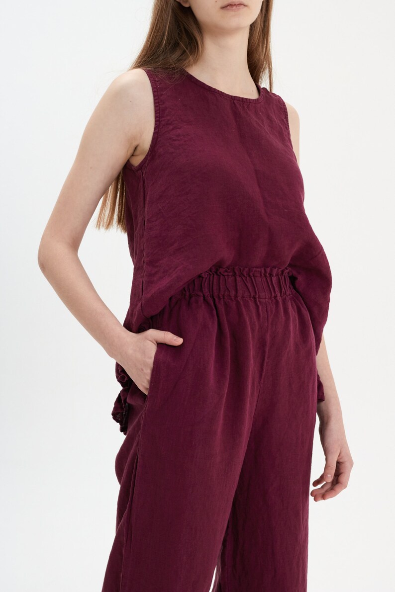 May include: A burgundy linen tank top and matching wide-leg pants. The top has a scoop neck and the pants have an elastic waistband.