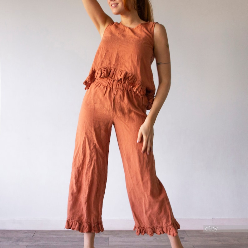 May include: A terracotta-colored linen pants and top set with a ruffled hem. The top is sleeveless and the pants are cropped.