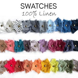 May include: A collection of 100% linen fabric swatches arranged in three rows. Each square piece of fabric features frayed edges and is secured with a small brass-colored metal stud. The text "SWATCHES 100% Linen" is printed at the top.