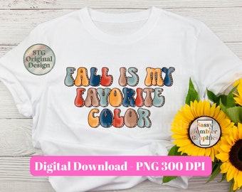 Può includere: Una t-shirt bianca con il testo FALL IS MY FAVORITE COLOR in un carattere multicolore in stile bolla. Il design include sfumature di blu, arancione, rosso e marrone. Un logo circolare riporta STG Original Design e un secondo Sassy Tumbler Graphics.