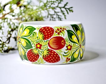 May include: White wooden bangle with a hand-painted design of red strawberries, green leaves, and yellow flowers.