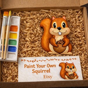 May include: A paint-your-own squirrel kit in a cardboard box. The kit includes a ceramic squirrel holding an acorn, a paint palette with brushes, and a sign that reads "Paint Your Own Squirrel Etsy."