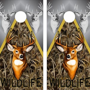 May include: Two rectangular cornhole boards featuring a graphic of a brown deer head with antlers centered over a camouflage pattern of tall grass. Above the deer, two grayscale deer heads flank a circular hole. The word WILDLIFE is printed in black.