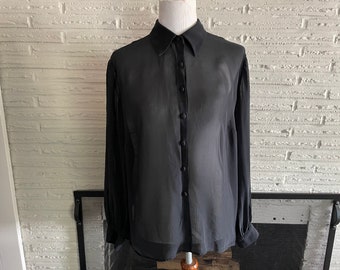 May include: A black sheer button-down shirt with long sleeves and a collared neckline.