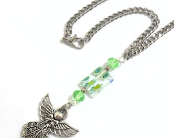 May include: A silver-toned metal chain necklace featuring a dangling angel charm. The pendant is accented with a rectangular glass bead containing green and blue floral patterns, flanked by two round, translucent lime green faceted beads.