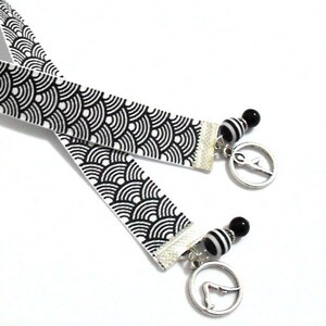 This yoga and pilates ribbon bookmark with metal charms in various yoga poses would be enjoyed by the spiritual person.  A unique item for yoga and pilates instructors.  

The black and white grosgrain ribbon is 11 inches (28cm) in length.   The total length of the bookmark is 13-14 inches (33-36cm).  The width of the ribbon is 5/8 inches (16mm).  The solid black beads are glass and the black/white striped beads are of a resin material.
