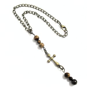 Cross charm car rear view mirror car and SUV rearview Christian religious dangle auto accessory.  Great for nuns, priests, religion teachers, theology professors or for anyone with faith.   Length:  Chain is 9 inches when opened, and 4 1/2 inches when closed.  Embellishment port ion is approximately 3 inches in length. Clasp:  12mm lobster claw clasp Beads:  Brown with beige Tiger Eye Gemstone Charm:  Bronze tone metal cross