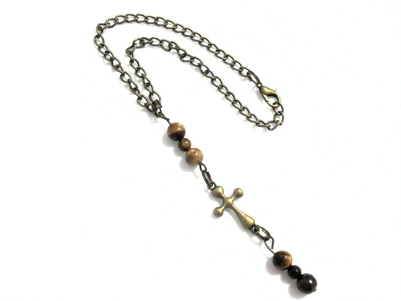 Cross charm car rear view mirror car and SUV rearview Christian religious dangle auto accessory.  Great for nuns, priests, religion teachers, theology professors or for anyone with faith.   Length:  Chain is 9 inches when opened, and 4 1/2 inches when closed.  Embellishment port ion is approximately 3 inches in length. Clasp:  12mm lobster claw clasp Beads:  Brown with beige Tiger Eye Gemstone Charm:  Bronze tone metal cross