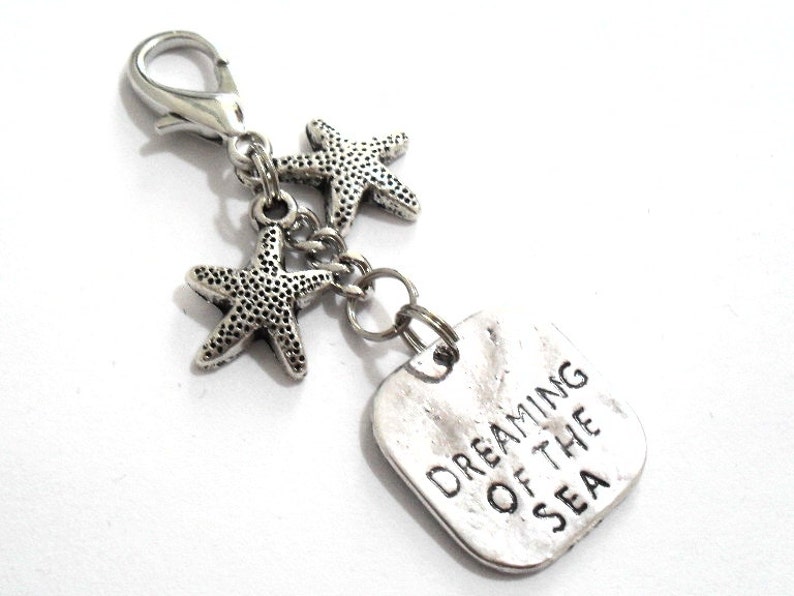 A 2 1/2 inch beach planner charm, starfish keyring clasp or sea pendant zipper pull.  The DREAMING OF THE SEA pendant has an attractive watery/wave appearance.  The 18mm lobster clasp is large enough to fit the majority of zippers and keychains.