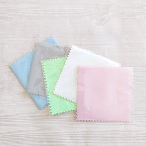 Può includere: Quattro panni in microfibra per la pulizia in diversi colori: azzurro, grigio, verde chiaro e rosa. I panni sono confezionati in plastica trasparente.