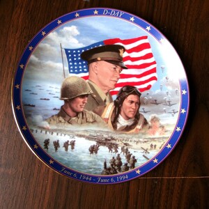 May include: A commemorative porcelain plate with a blue and gold border, featuring a depiction of D-Day. The plate shows a scene of soldiers landing on the beach, with a US flag and portraits of military leaders. The text "D-Day" and "June 6, 1944 - June 6, 1994" is printed on the plate.