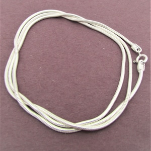 May include: A silver snake chain necklace with a lobster clasp closure.