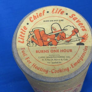 May include: Vintage cylindrical container with a paper label featuring a cartoon character and text. The label reads "Little Chief Life Savers" and "Burns One Hour." The container is for fuel for heating, cooking, and emergencies.
