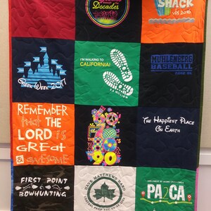 May include: A quilt made from a variety of t-shirts, each with a different design and text. The quilt is made up of 9 squares. The top left square is red with the text "ARCADIA UNIVERSITY". The top middle square is black with a neon pink circle with the text "Greeks through the Decades". The top right square is orange with the text "SURF SHACK vbs 2016". The middle left square is navy blue with a blue castle and the text "Greek Week 2017". The middle middle square is green with a white footprint and the text "I'M WALKING TO CALIFORNIA! 5.6 MILLION". The middle right square is navy blue with the text "MUHLENBERG BASEBALL 2012 DL". The bottom left square is orange with the text "REMEMBER that THE LORD is GREAT & AWESOME". The bottom middle square is white with a multi-coloured graphic of the 60s, 70s, 80s, and 90s. The bottom right square is navy blue with the text "The Happiest Place On Earth".