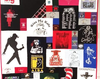 Può includere: Una trapunta patchwork realizzata con varie magliette nere, bianche, rosse e blu con stampe grafiche e testi di produzioni di teatro musicale tra cui Brigadoon, West Side Story, Oklahoma, The Sound of Music e Godspell.