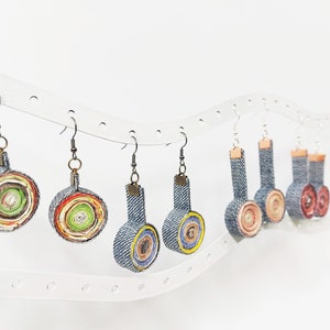 以下が含まれることがあります： さまざまなパターンとデザインのカラフルなデニム製のイヤリングのコレクション。イヤリングは白い背景に表示されています。