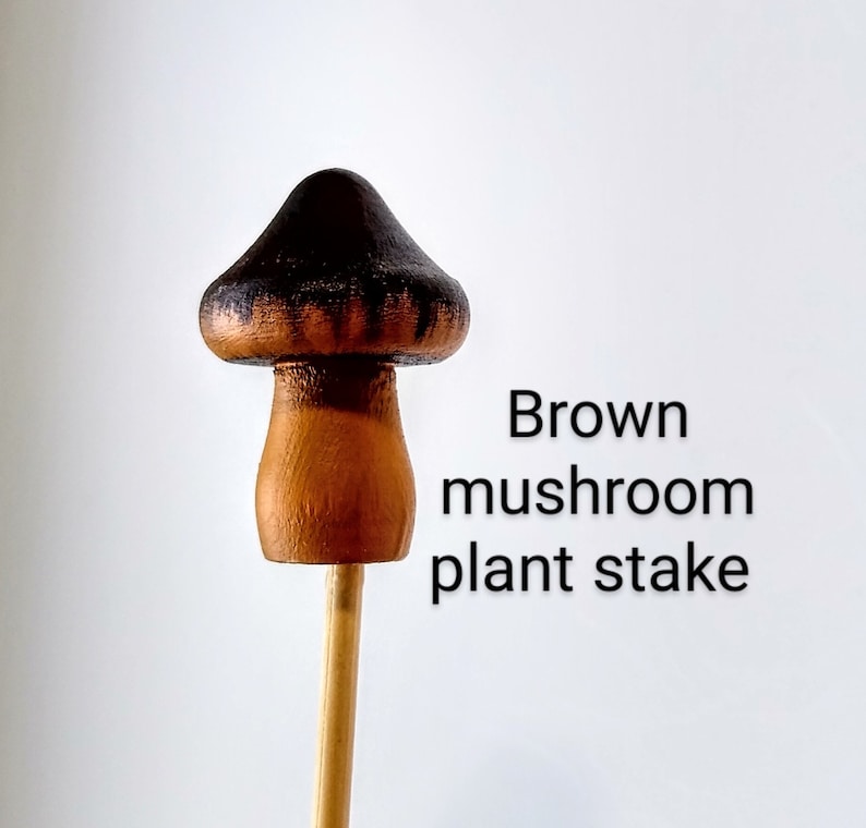 K&ouml;nnte beinhalten: Brauner, pilzf&ouml;rmiger Pflanzenstab. Der Pilz ist braun mit schwarzen Streifen bemalt. Der Stab ist aus Holz.