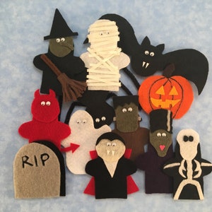 Puede incluir: Un conjunto de títeres de dedo de fieltro con varios personajes de Halloween, incluyendo una bruja, una momia, un murciélago, una calabaza, un diablo, un fantasma, un vampiro, Frankenstein, un personaje con un sombrero de copa y un esqueleto. Los títeres están hechos de fieltro y tienen ojos saltones.