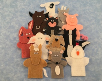 May include: A set of felt finger puppets featuring various farm animals, including a cow, goat, pig, cat, dog, rabbit, sheep, horse, mouse, chicken, and skunk. The puppets are all brightly colored and have googly eyes.