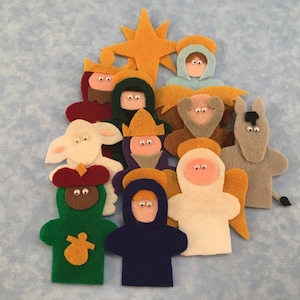 May include: A set of felt finger puppets depicting characters from the Nativity story. The puppets include a shepherd, a donkey, a sheep, three wise men, an angel, and a star.