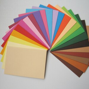 May include: A fan-shaped arrangement of 20 different coloured cardstock paper sheets. The colours range from light blue to dark brown.