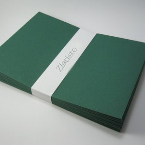 May include: A stack of dark green envelopes with a white label that says "Zlatisto" on it.