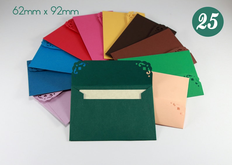 May include: A set of 25 envelopes in various colors, including red, pink, yellow, brown, green, blue, and peach. Each envelope has a decorative, lacy design around the edges and measures 62mm x 92mm.
