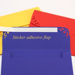 May include: Three envelopes with decorative edges. The top envelope is yellow, the middle envelope is blue with a white sticker flap that says "Sticker adhesive flap", and the bottom envelope is red.