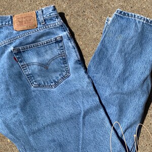 May include: A pair of light blue denim jeans with a brown leather patch that says "Levi Strauss & Co.".
