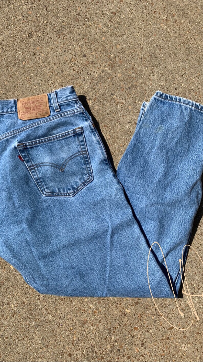 May include: A pair of light blue denim jeans with a brown leather patch that says "Levi Strauss & Co.".