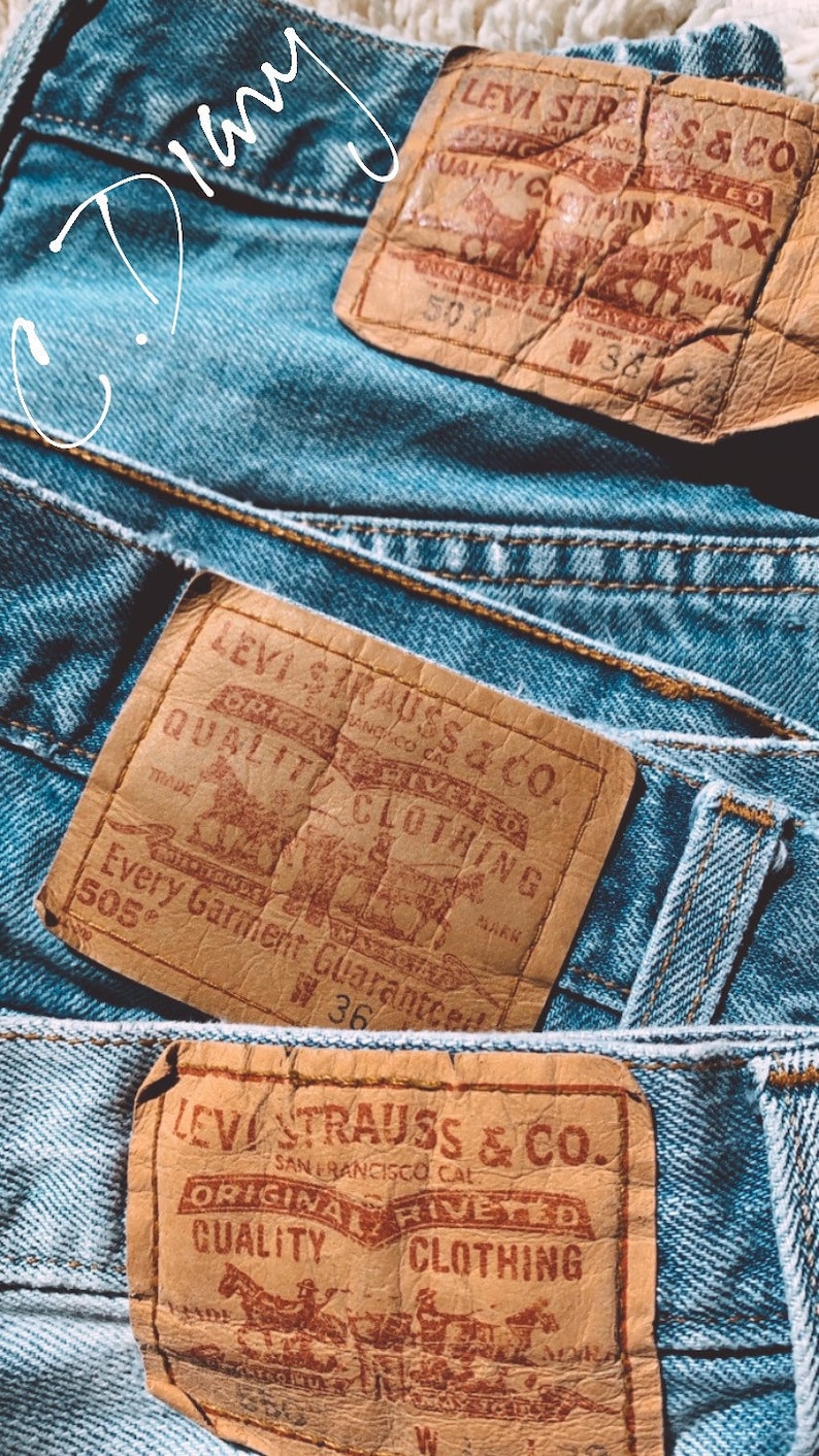 May include: Three vintage Levi Strauss & Co. denim jean patches with brown leather backing and red printed text. The patches feature the Levi Strauss & Co. logo, the words "Original  Riveted Quality Clothing", and the text "Every Garment Guaranteed".