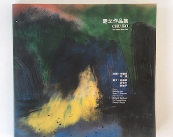 May include: A book cover with a colorful abstract painting in shades of blue, green, yellow, and red. The title of the book is "Chu Ko Works" in Chinese characters and English. The book is about the artist Chu Ko.