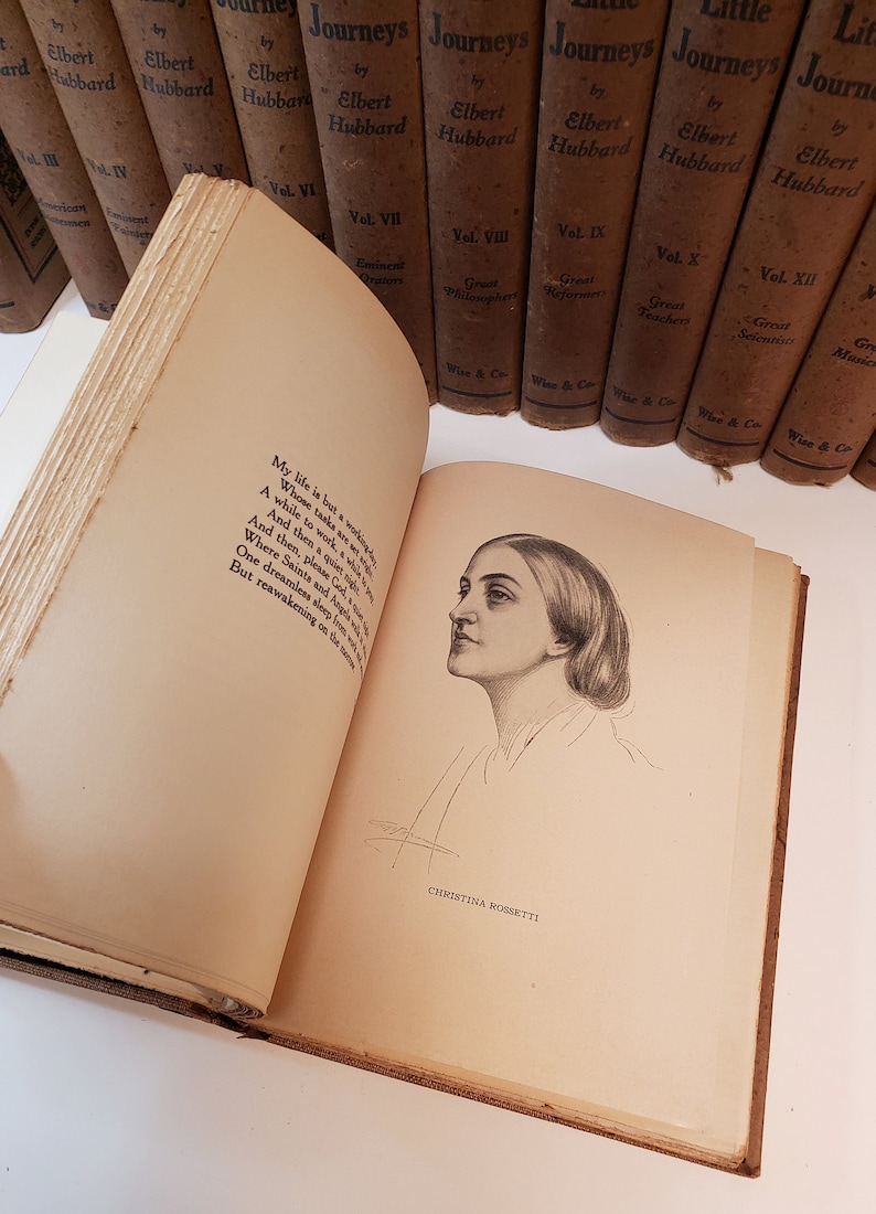 May include: An open book with a poem by Christina Rossetti. The book is titled "Journeys" and is part of a series of books by Elbert Hubbard. The book is open to a page with a black and white illustration of a woman's face.