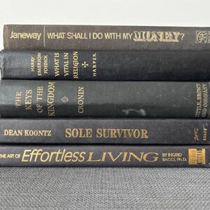 May include: A white ceramic mug with a black handle and the text "But First, Coffee" in a black, handwritten-style font. The mug is on a white surface.