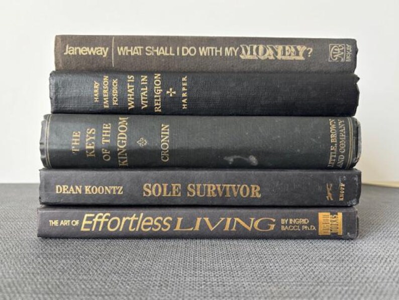 May include: A white ceramic mug with a black handle and the text "But First, Coffee" in a black, handwritten-style font. The mug is on a white surface.