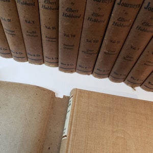 May include: A set of ten brown hardcover books titled "Little Journeys" by Elbert Hubbard. Each book features a different volume number and subject, such as "Eminent Painters", "English Authors", and "Great Philosophers".